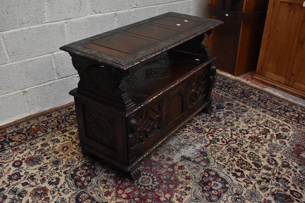 A 1920s carved oak monk's bench with carved and panelled back above the hinged seat, width 107cm, - Image 3 of 7