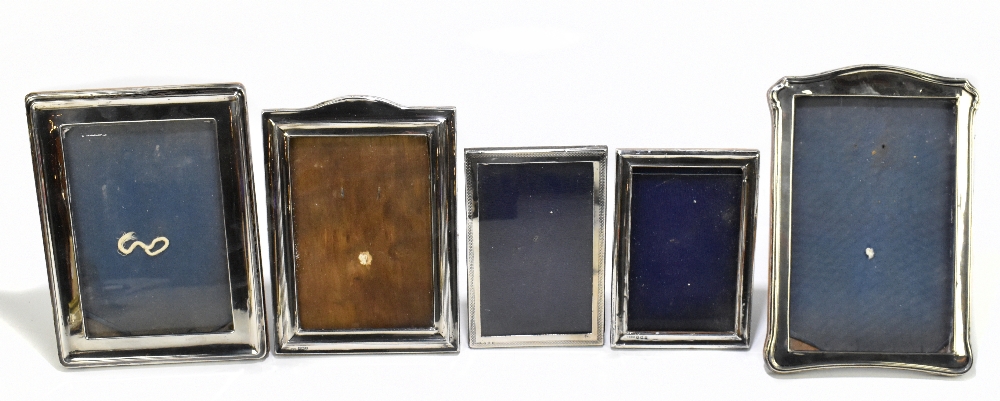 Three early 20th century hallmarked silver mounted photograph frames, the largest an oak backed