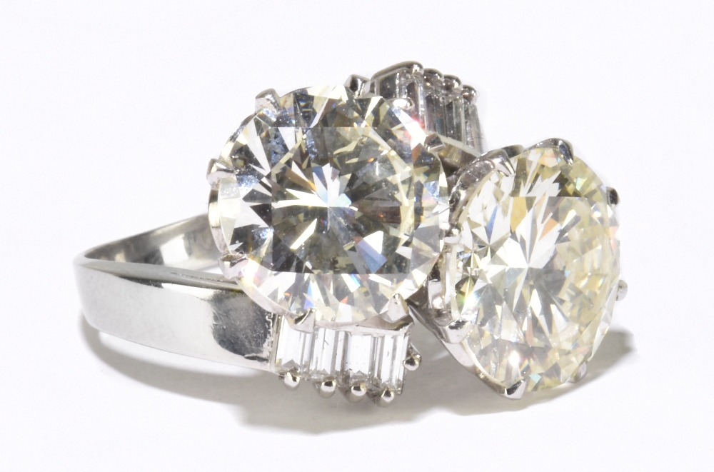 A white metal diamond crossover ring with twin round brilliant cut stones weighing 4.20ct and 3.