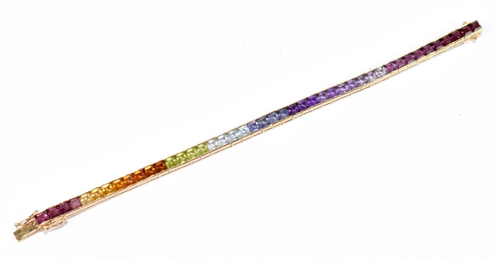 A 14ct yellow gold rainbow gem set calibre cut line bracelet, set with garnets, amethysts,