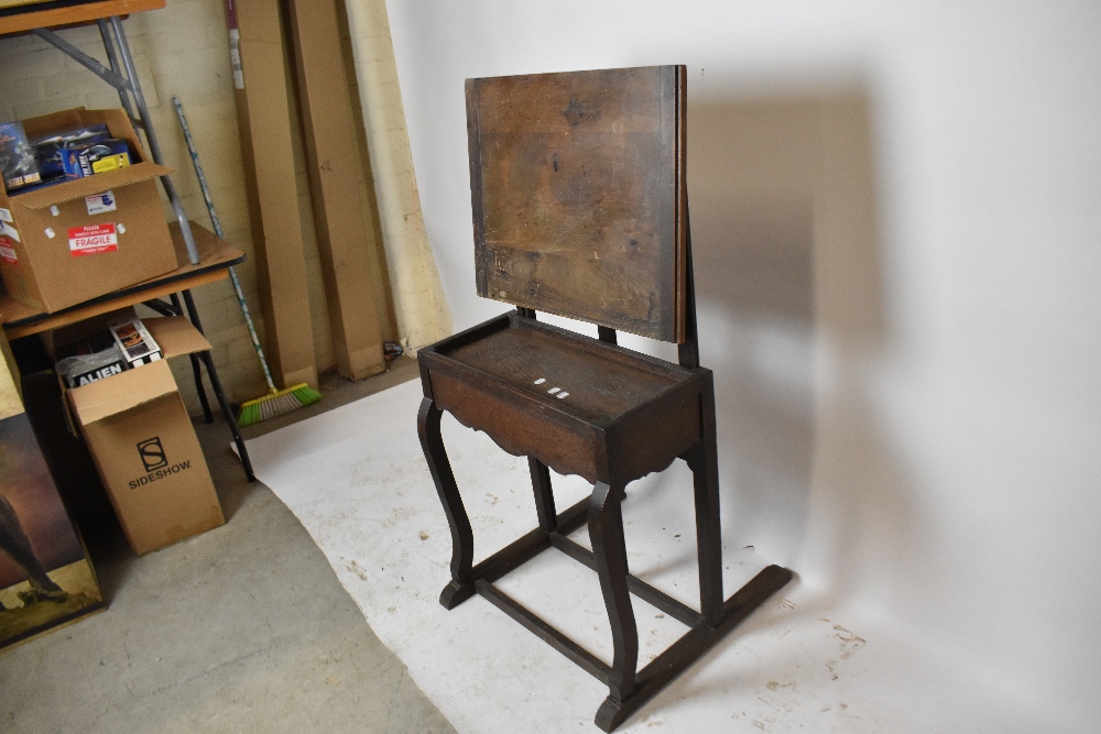 An unusual early 20th century artists easel/table, with adjustable rectangular panel above base