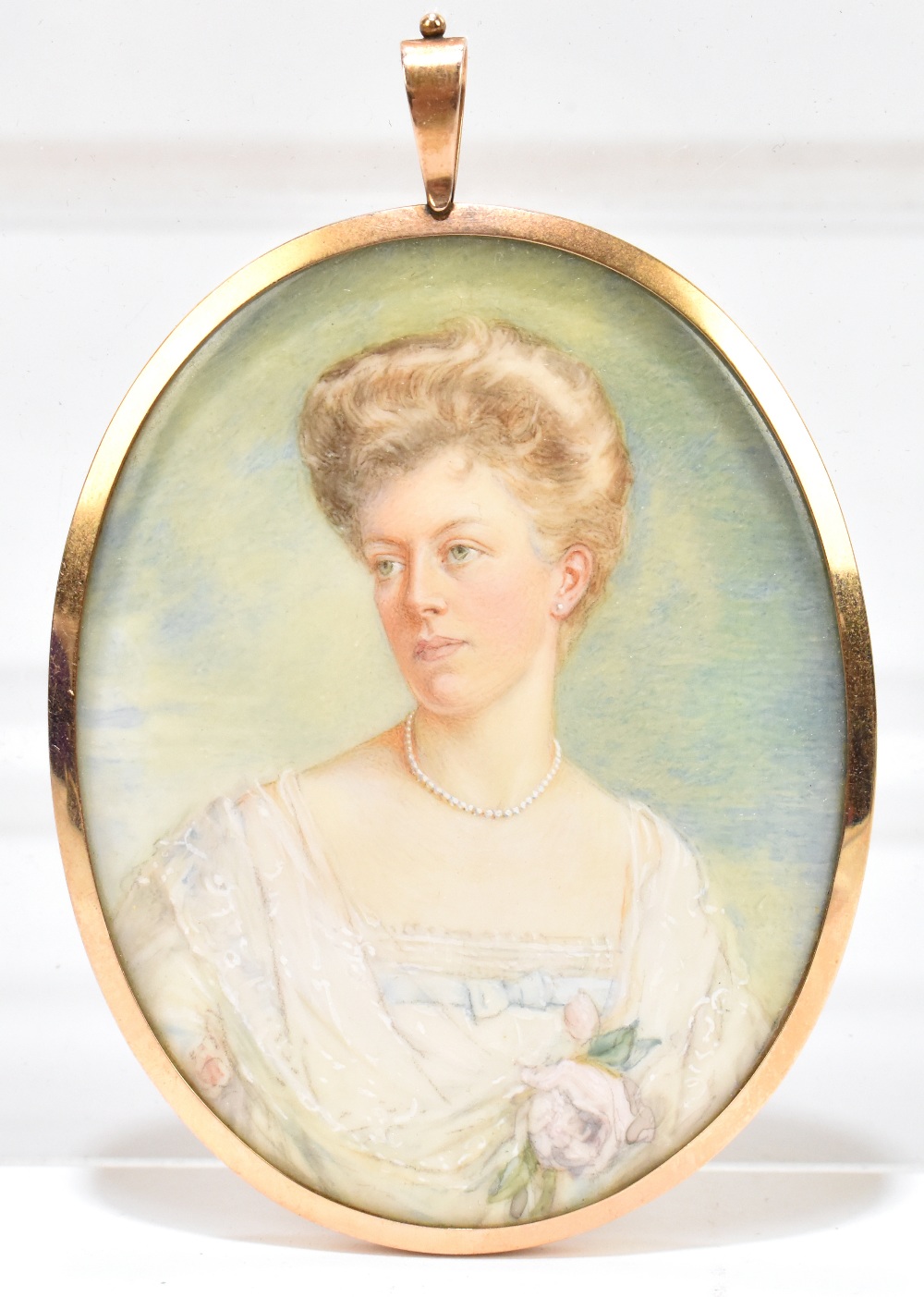 An Edwardian miniature portrait on ivory, the female sitter wearing a lace trimmed white dress