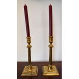 A pair of mid-18th century brass candlesticks with fluted central column to square sectioned base,