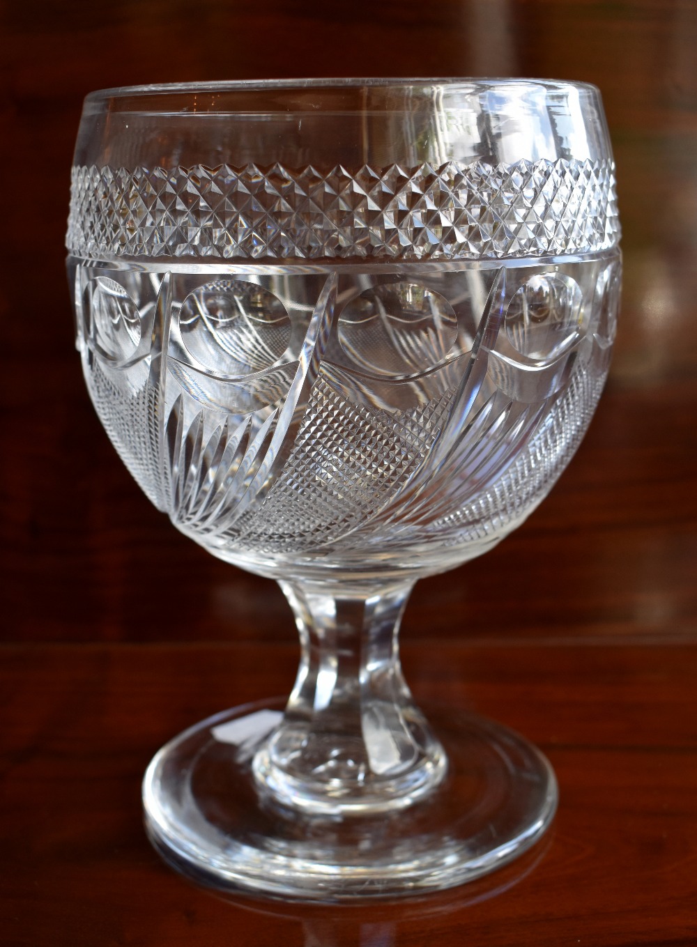 A large 19th century cut glass goblet with band of hobnail detail above wrythen decorated bowl and