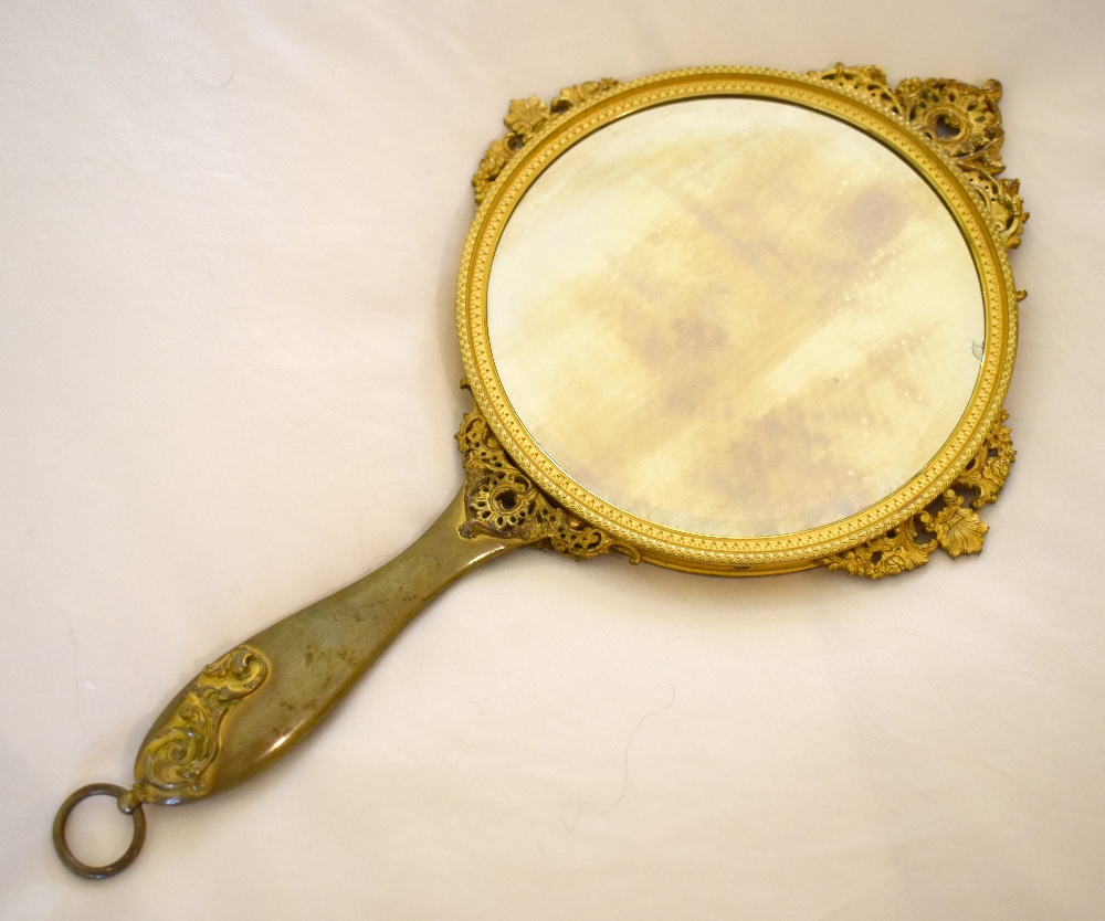 An early 20th century French gilt metal and enamel decorated hand mirror, the back decorated with