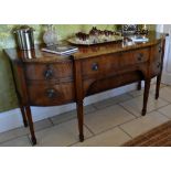 A late George III mahogany sideboard, the crossbanded and ebony strung shaped top above central