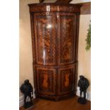 An early 19th century Dutch marquetry inlaid freestanding bowfronted corner cupboard, the moulded