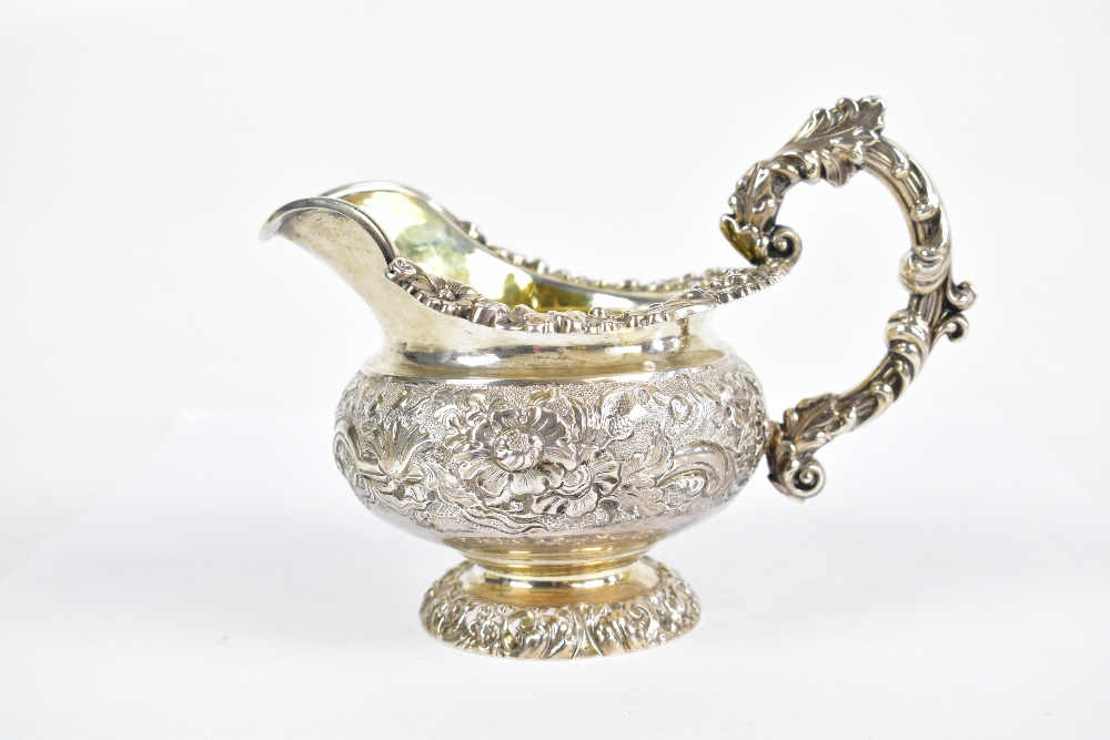 A George IV hallmarked silver cream jug with ornate scroll handle and embossed main body decorated - Bild 3 aus 6