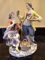 An early 20th century Meissen porcelain figure group of a man holding a basket of flowers beside a
