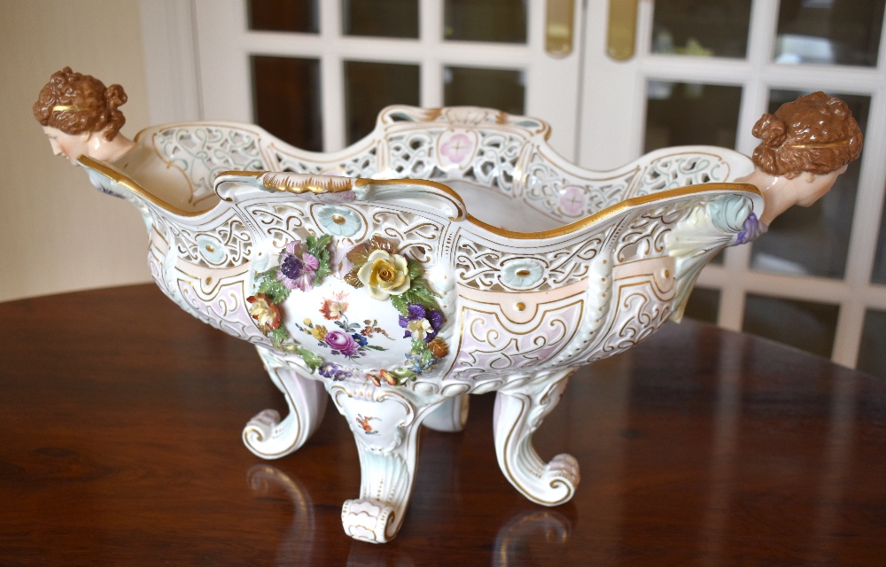 A large circa 1900 Continental porcelain centrepiece with pierced shaped rim, twin female mask