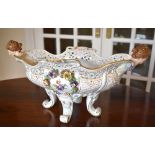 A large circa 1900 Continental porcelain centrepiece with pierced shaped rim, twin female mask