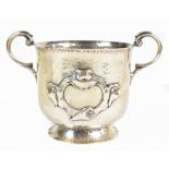 A late Victorian hallmarked beaten silver Arts & Crafts twin handled cup, with stylised central