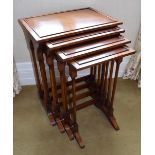 A reproduction mahogany quartetto nest of tables, each raised on twin turned supports to shaped