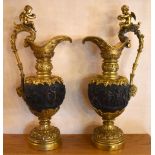 A large pair of decorative 20th century bronze ewers, each with cherub surmount above the