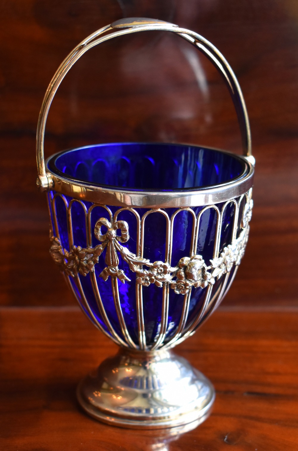 HASELER BROTHERS; an Edwardian hallmarked silver swing handled sugar bowl with blue glass liner,