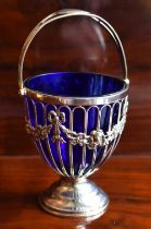 HASELER BROTHERS; an Edwardian hallmarked silver swing handled sugar bowl with blue glass liner,