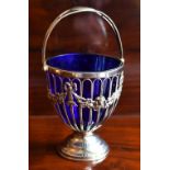 HASELER BROTHERS; an Edwardian hallmarked silver swing handled sugar bowl with blue glass liner,