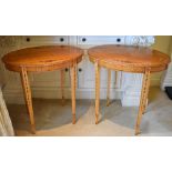 A pair of painted satinwood oval occasional tables, each top painted with four floral sprays, with