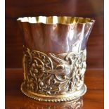 WILLIAM COMYNS; a Victorian hallmarked silver gilt vase with crimped rim and embossed body decorated