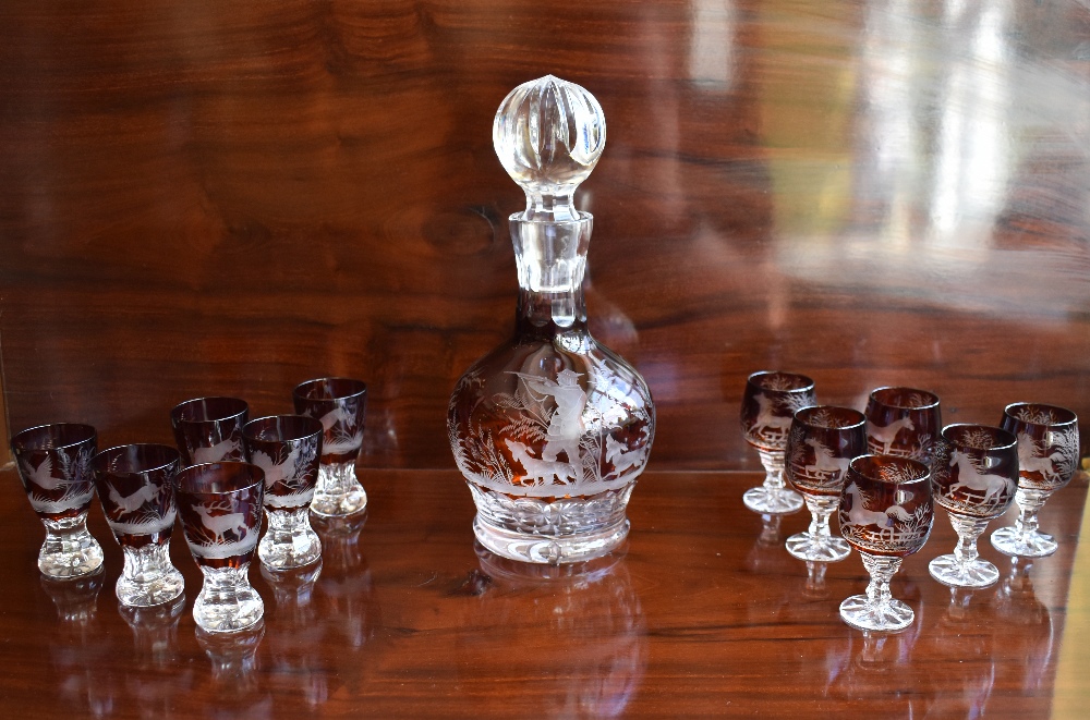 An early 20th century cut glass ruby tinted liqueur set comprising a decanter with substantial