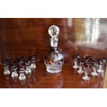 An early 20th century cut glass ruby tinted liqueur set comprising a decanter with substantial