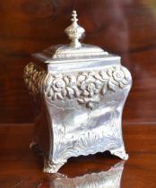 An early Victorian hallmarked silver tea caddy with hinged lid above floral embossed band, lower