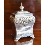 An early Victorian hallmarked silver tea caddy with hinged lid above floral embossed band, lower