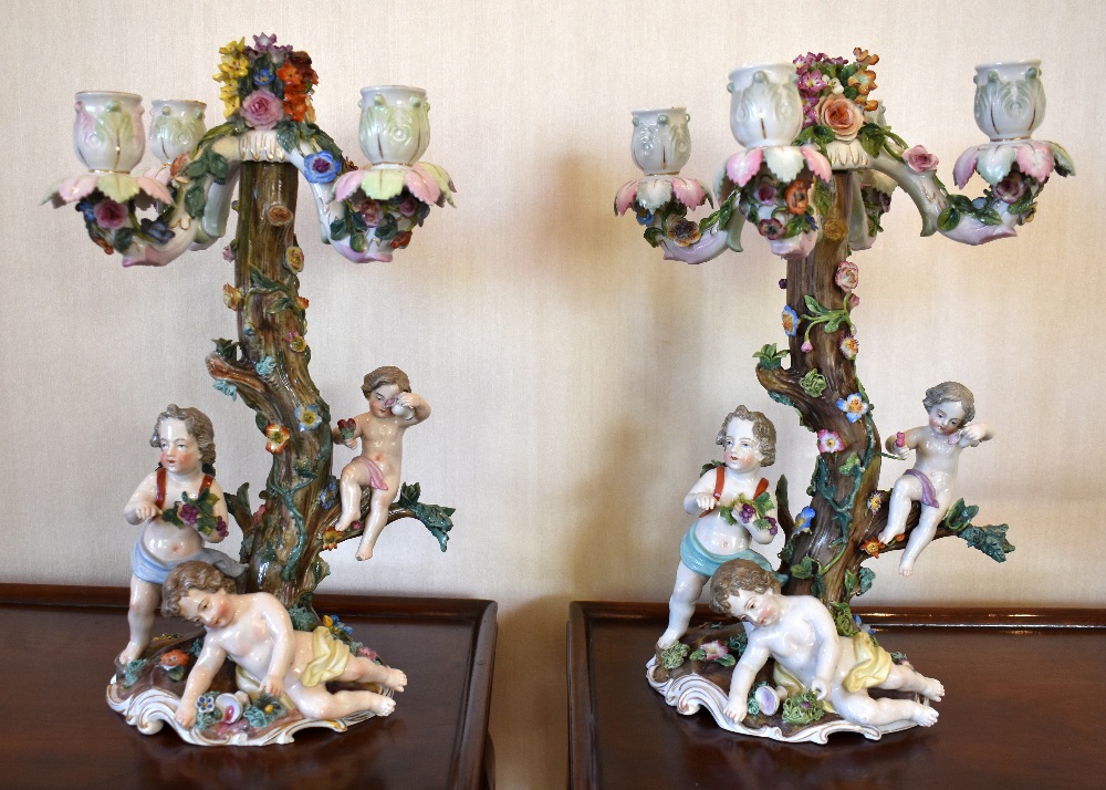 Two late 19th century German porcelain candelabra, each floral encrusted throughout with four