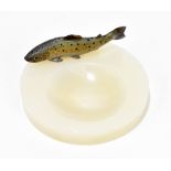 A 1930s polished white onyx pin dish surmounted with a cold painted bronze salmon, diameter 12cm.