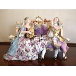 A Meissen Marcolini period porcelain group of a couple seated on an elaborate settee, playing