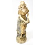 A large late 19th century carved alabaster figure of a young woman holding a tambourine and raised
