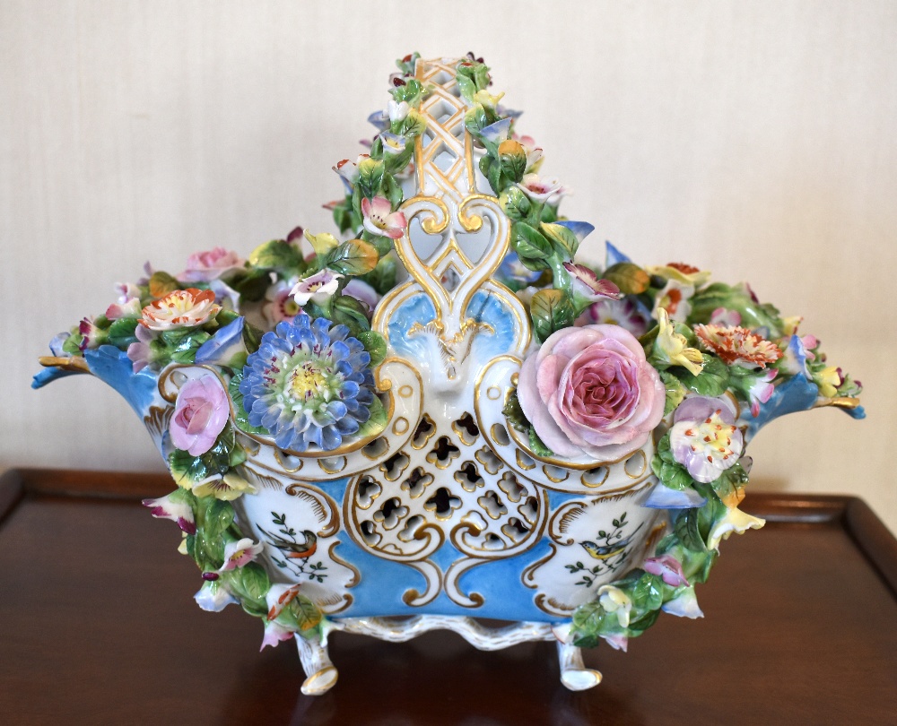 A mid/late 19th century floral encrusted porcelain basket with fixed handle and hand painted