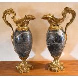 A pair of gilt metal mounted and polished stone ewers, with pierced scrolling handles and Rococo