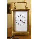 A circa 1900 French brass carriage clock, the rectangular white enamelled dial set with Roman
