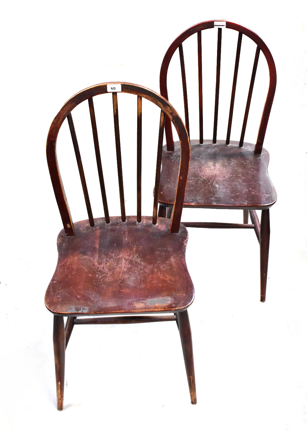 ERCOL; a set of three stained comb back chairs raised on turned stretchered supports (3).