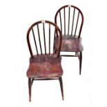 ERCOL; a set of three stained comb back chairs raised on turned stretchered supports (3).