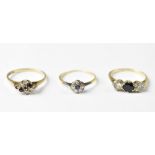 Three 9ct gold dress rings, one with a central blue stone flanked by white stones either side,