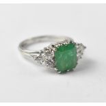 An emerald diamond and white metal ring, with claw set square cut emerald, approx 6.7 x 7.