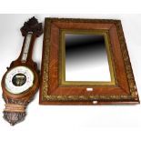 An early 20th century oak wall mirror with ornate applied gilded decoration to the frame,