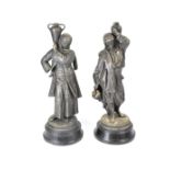 A pair of spelter figures of water carriers modelled as a man and woman in Islamic robes,