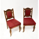 A set of six Edwardian oak dining chairs, carved back rail,