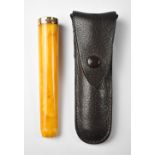 An amber cheroot/cigar holder with 9ct gold ferrule, length 9cm, in a small leather pouch.