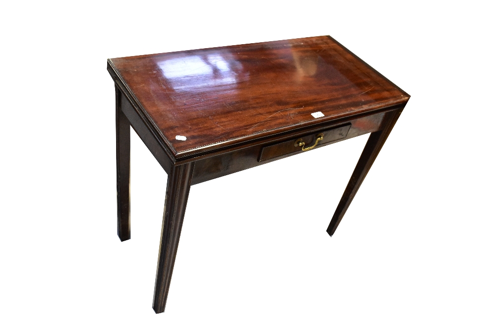 An early 20th century mahogany fold-over tea table with single frieze drawer,