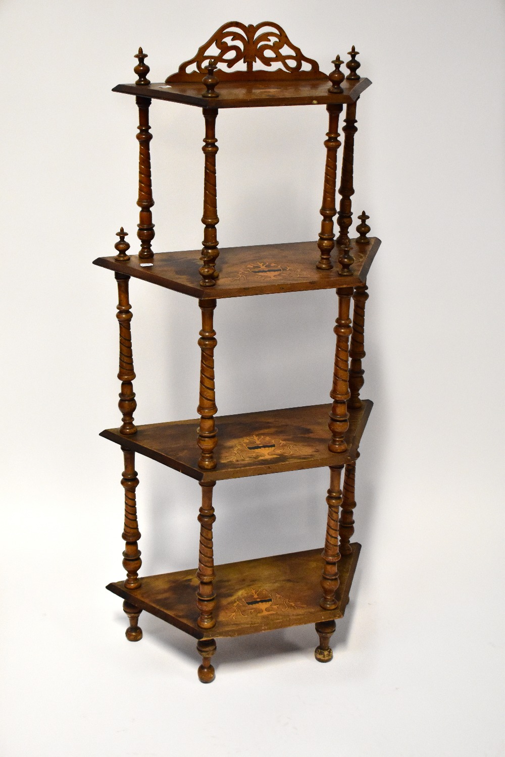 An Edwardian walnut inlaid four-tier whatnot, each tier supported by wrythen turned supports,