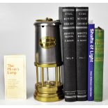 An Ashington Colliery brass and steel safety lamp together with two volumes of E.