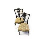 A pair of Victorian ebonised splat back salon chairs with pierced vase shaped decoration to the