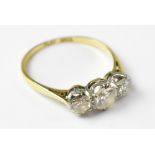 An 18ct gold and platinum three-stone diamond ring, with three claw set brilliant cut diamonds,