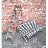 A wrought iron framed slatted garden bench,