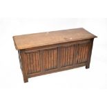 An early 20th century oak blanket box with hinged lid above four panels to the front and two panels