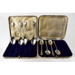 Two non-matching cased sets of hallmarked silver golfing related teaspoons, both of four teaspoons,